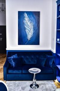 un sofá azul en una sala de estar con una pintura en Supreme Tatarska, en Przemyśl