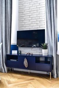 Una cómoda azul en una habitación con una pared de ladrillos. en Supreme Tatarska, en Przemyśl 28 fotos más