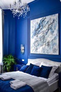 a blue bedroom with a large painting on the wall at Supreme Tatarska in Przemyśl +28 photos