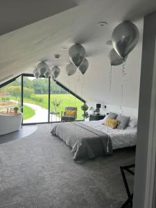 a bedroom with a bed with balloons hanging from the ceiling at Waters Edge, Eaton in Congleton