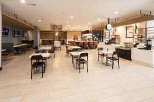 a dining room with tables and chairs in a restaurant at Holiday Inn & Suites Detroit - Troy by IHG in Troy
