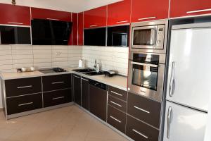 a kitchen with black cabinets and a white refrigerator at Vila Merkuri - 3-Storey Villa with Sea View in Vlorë
