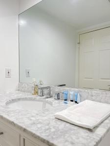 Baño blanco con lavabo y espejo en *WEHO/Beverly Hills* Luxury 2BD/2.5BA + Balconies, en Los Ángeles