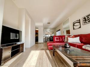 sala de estar con sofá rojo y TV en *WEHO/Beverly Hills* Luxury 2BD/2.5BA + Balconies, en Los Ángeles