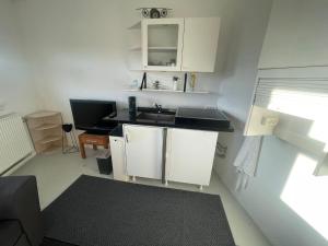 a small kitchen with white cabinets and a sink at Airport Room in Copenhagen