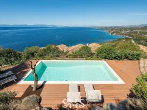 a swimming pool on a deck next to the water at Villa Emilia in Terra Mala