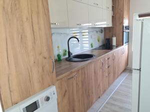 a kitchen with wooden cabinets and a sink at Leki Apartman in Travnik