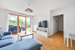 a living room with a blue couch and a table at Le Lumina - 6 pers - Proche Orly - Jardin in Rungis