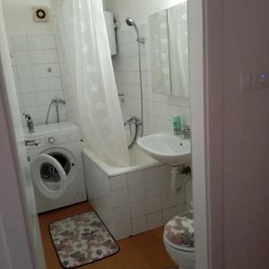 een badkamer met een wasmachine en een wastafel bij Cosy apartment in Jajce