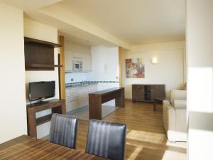 una cucina e un soggiorno con tavolo e sedie di Apartamentos MS Pepita a Benalmádena