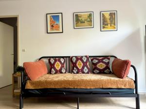 um sofá com almofadas na sala de estar em Charme et Passion By UTA HOUSE em Saint-Denis