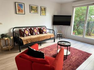 a living room with a couch and a tv at Charme et Passion By UTA HOUSE in Saint-Denis