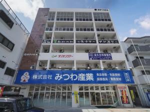 a building with a blue sign in front of it at Chura Gahna House Tsubogawa - Vacation STAY 40171v in Naha