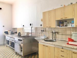 a kitchen with a sink and a stove and cabinets at Budova U dvojice in Nové Město na Moravě