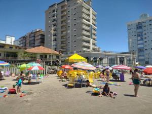 un groupe de personnes assises sur une plage avec des parasols dans l'établissement Pertinho do Beto Carrero Jw, à Navegantes