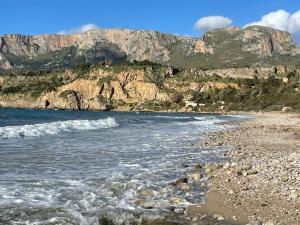 una spiaggia rocciosa con una montagna sullo sfondo di Villa Vittoria a Trappeto