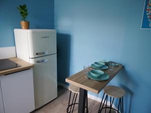 uma pequena cozinha com uma mesa de madeira e um frigorífico em Joli cocon - Dijon centre ville em Dijon