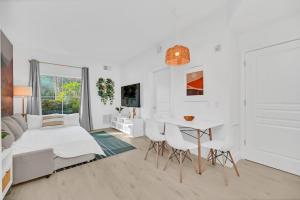 a white room with a bed and a table and chairs at Boho Oasis 1 mile Disney Springs in Orlando