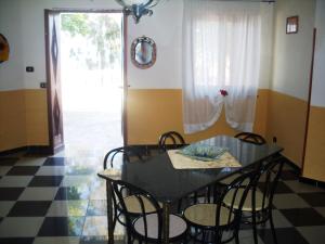 Un comedor con una mesa y sillas negras. en Villa del Capo, en Capo Vaticano