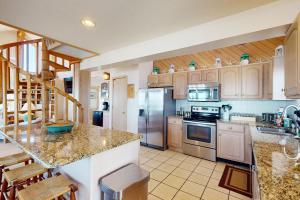 a kitchen with stainless steel appliances and wooden cabinets at Argonauta #27-2 in Avon