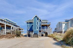 a blue house on the beach next to some houses at Argonauta #27-2 in Avon