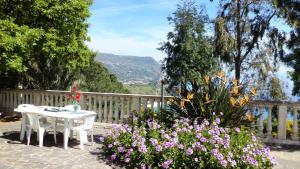 una mesa blanca y sillas en un jardín con flores en Villa del Capo, en Capo Vaticano 21 fotos más