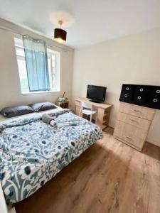 a bedroom with a bed and a desk at Close to Central London in London