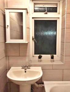 a bathroom with a sink and a window at Close to Central London in London