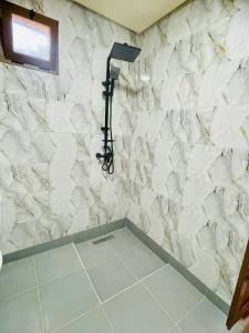 a shower in a bathroom with a white marble wall at Villa Baddi Marrakech in Marrakesh