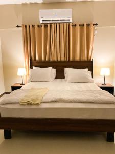 - une chambre avec un grand lit et deux lampes dans l'établissement Furnished luxury Vacation Apartment in DHA Phase 8, à Karachi