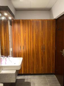 La salle de bains est pourvue d'un lavabo et de placards en bois. dans l'établissement Furnished luxury Vacation Apartment in DHA Phase 8, à Karachi