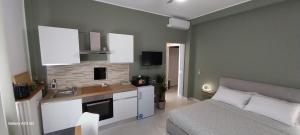 a bedroom with a bed and a kitchen with white cabinets at Little Sweet Home - Fiera Milano in Pero +27 photos