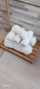 a pile of white towels on a wooden tray at Little Sweet Home - Fiera Milano in Pero