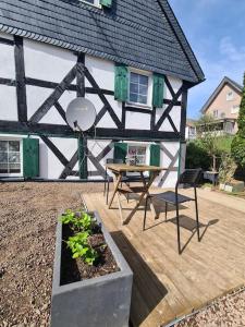 a house with a table and a chair on a patio at Ferienwohnung Bergischer Dreiklang in Windeck