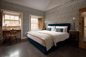 a bedroom with a large bed and a desk at Grieve's Cottage at Papple Steading in East Linton