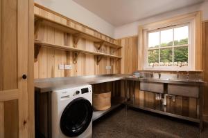 uma cozinha com uma máquina de lavar roupa e um lavatório em Grieve's Cottage at Papple Steading em East Linton