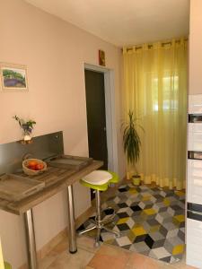 a kitchen with a table and a stool in a room at Sous Les Chênes in Saint-Martin-de-Brômes