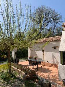 patio con tavolo di fronte a una casa di Sous Les Chênes a Saint-Martin-de-Brômes