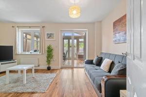 a living room with a couch and a tv at Cosy 3 Bedroom Spacious house. in Romford