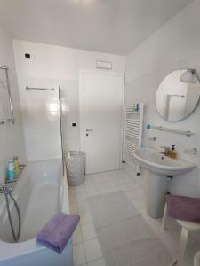 uma casa de banho branca com uma banheira e um lavatório em Nice apartment lake view & free parking em Pastrengo