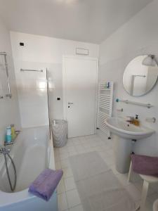 a white bathroom with a tub and a sink at Nice apartments lake view & free parking in Pastrengo +33 photos