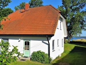 a white house with an orange roof at Holiday home Crane Coast in Kinnbackenhagen