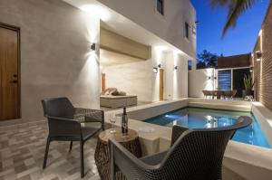 a swimming pool in a house with chairs and a table at Departamentos & Villa Monarka, 1 Block from Malecon! in La Paz