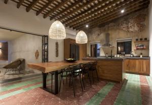 a large kitchen with a wooden table and chairs at Departamentos & Villa Monarka, 1 Block from Malecon! in La Paz