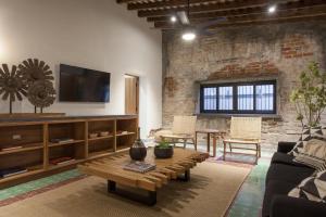 a living room with a couch and a table and a tv at Departamentos & Villa Monarka, 1 Block from Malecon! in La Paz