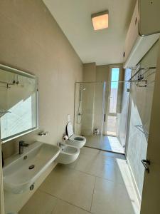 ein Badezimmer mit zwei Toiletten und einem Waschbecken und einer Dusche in der Unterkunft Sea La Vie Villa Palase in Palasë + 19 Fotos