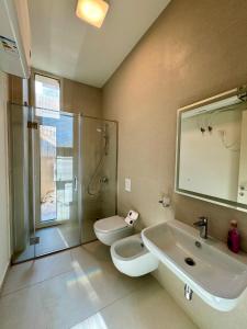 ein Badezimmer mit Waschbecken, Toilette und Dusche in der Unterkunft Sea La Vie Villa Palase in Palasë