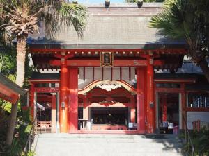 宮崎市にあるGUEST HOUSE aoshima tei - Vacation STAY 42002vのヤシの木の建物がある赤い寺院
