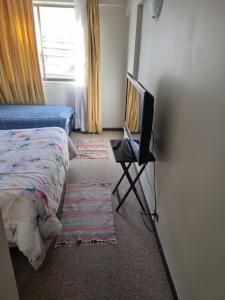 1 dormitorio con 1 cama y mesa con TV en Delpino Propiedades Veracruz, en Viña del Mar