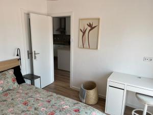 a bedroom with a bed and a table and a desk at Ton's Loft Caparica in Costa da Caparica